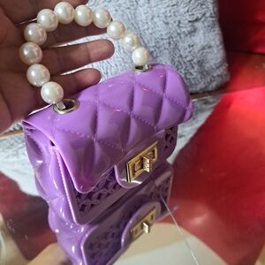 Wallet for girls and women. Purple with its pearl handle and has a long adjustab